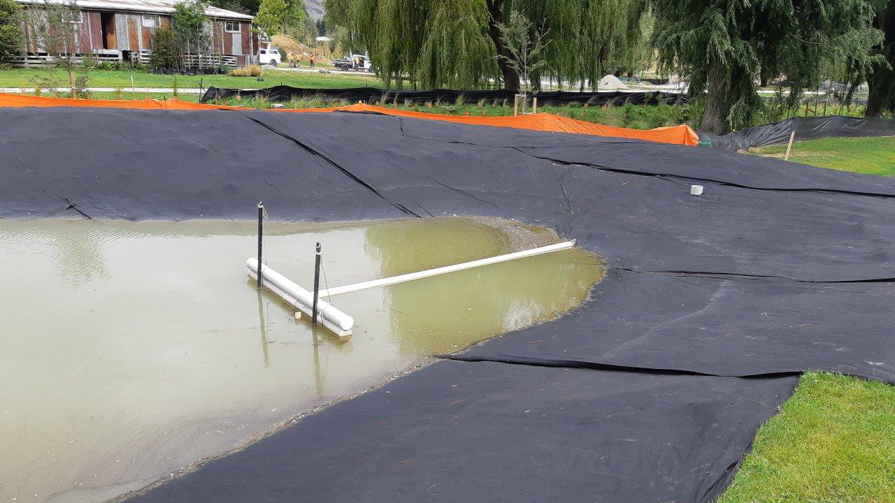 Settling pond with decanting structure in the middle, allows sediment to sink to bottom while taking clean water from top