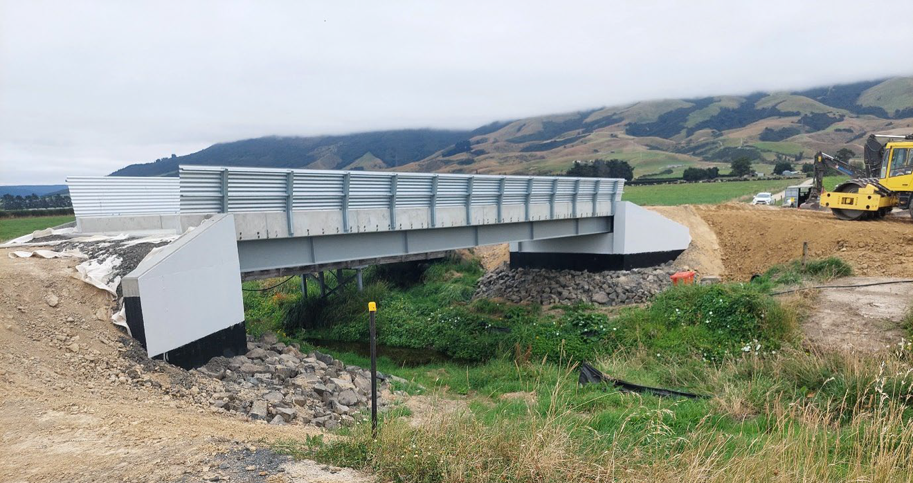 a bridge over a culvert with construction equipment beside it