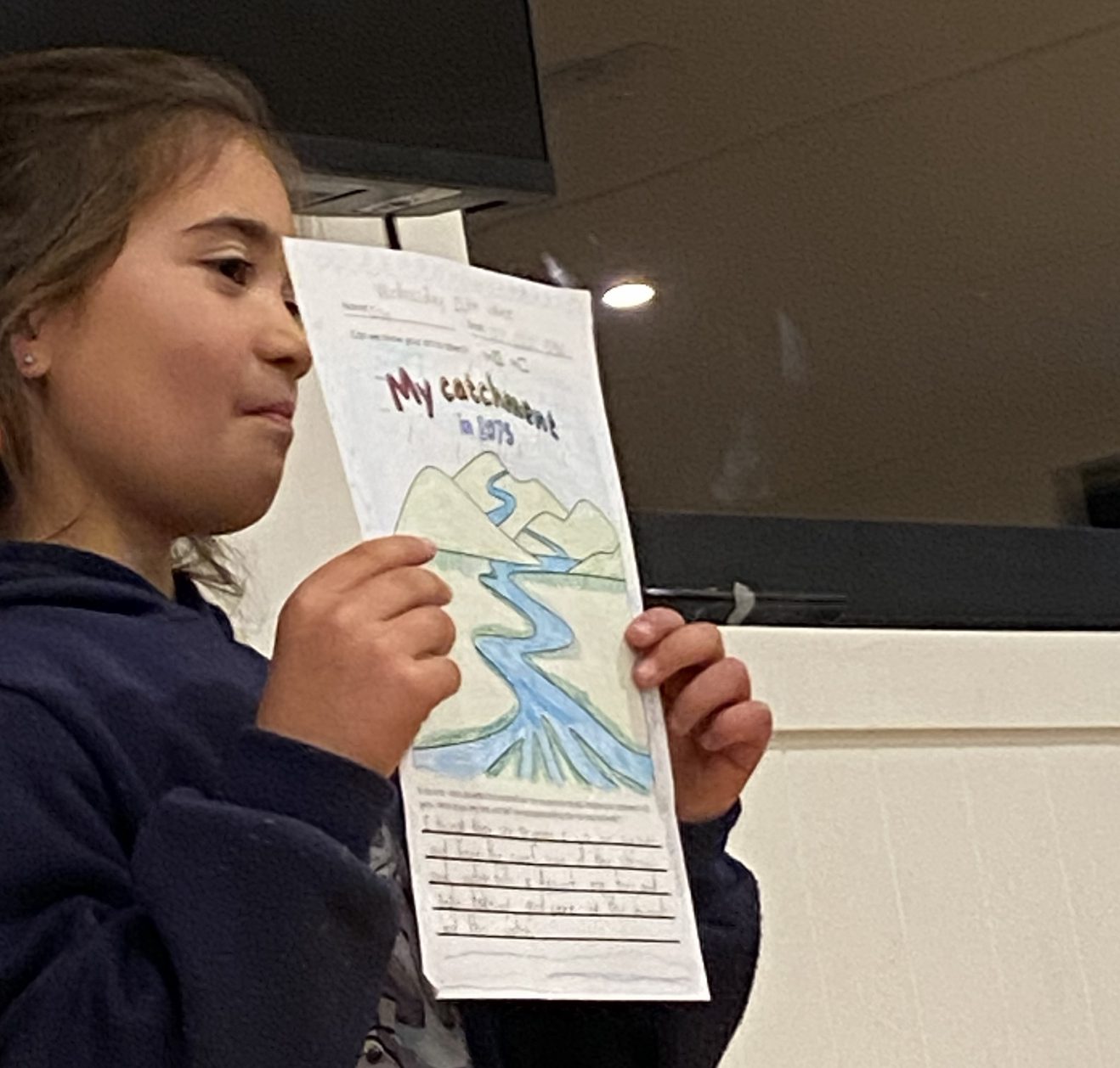 a child holding up a piece of paper