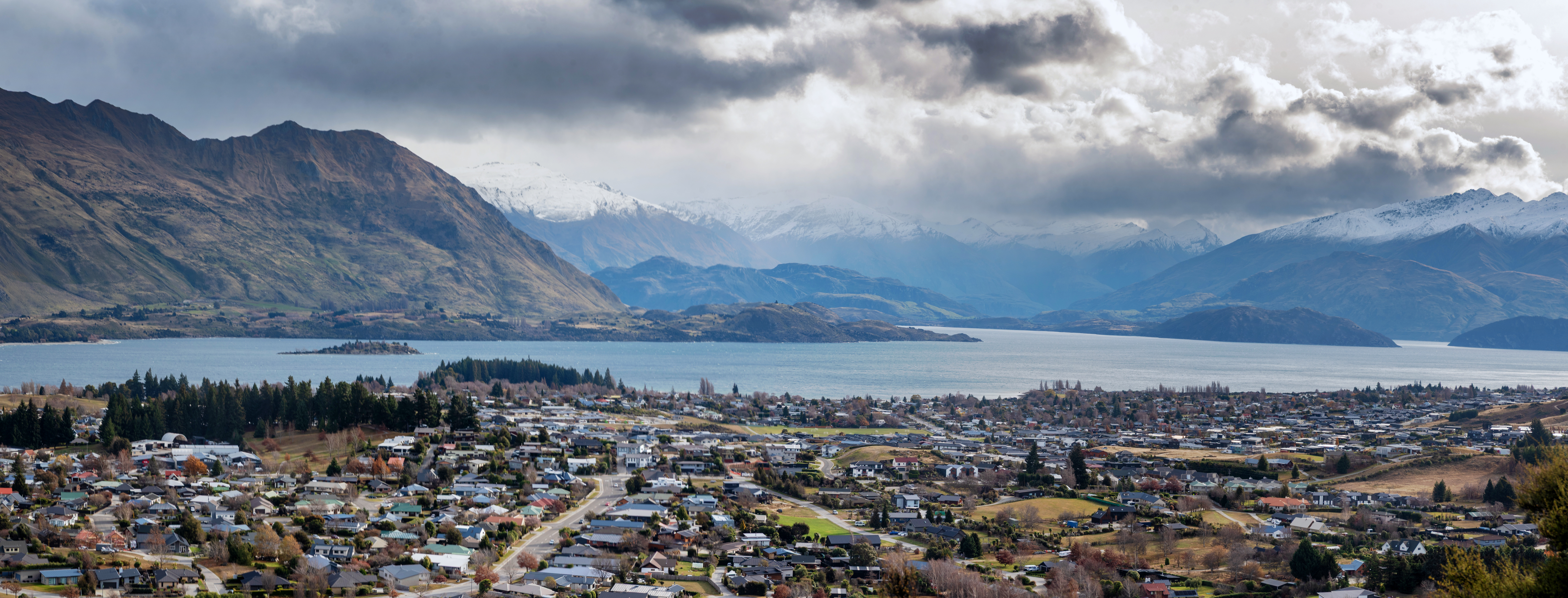 Elevated Panoramic View Of Wanaka, Otago, New Zealand With Lake Wanaka And Southern Alps In Background, As Seen From Mount Iron Peak Adobestock 1552909727