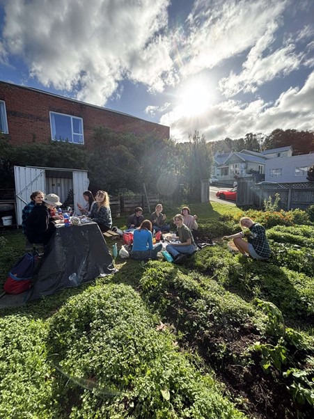 a group of people sitting in a garden on a sunny day