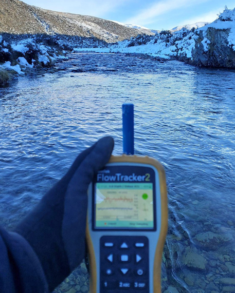 a close up of a hand holding An acoustic doppler velocimeter (ADV) in a river