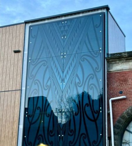 a panel on the side of a building with a design on it