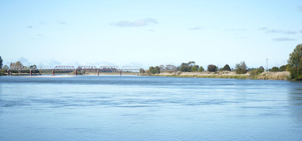 a bridge in the distance over a wide river