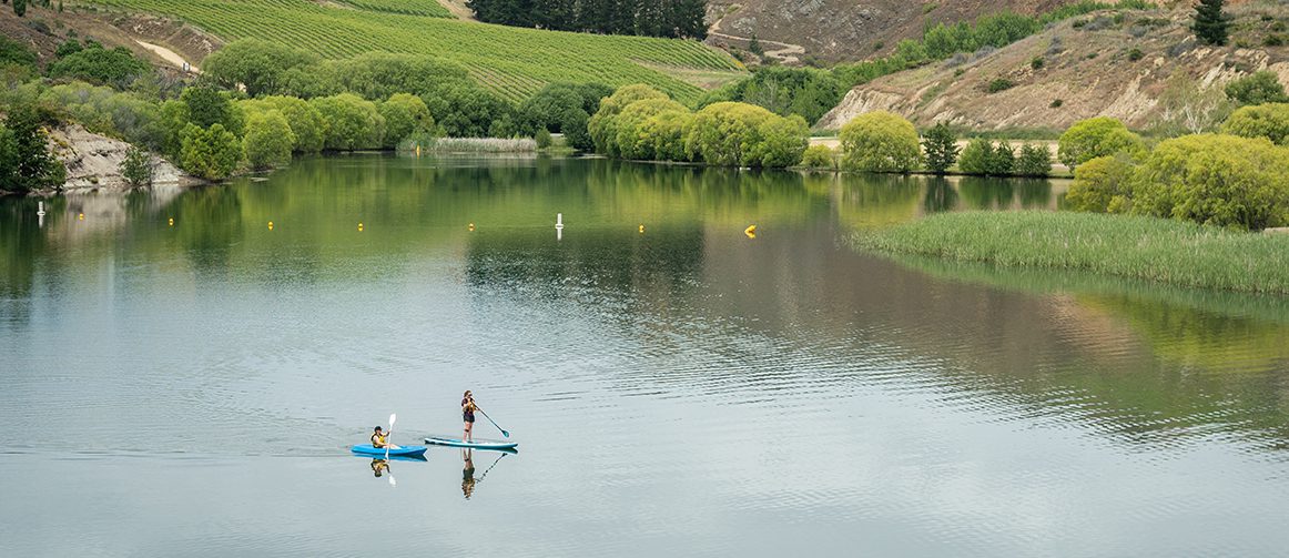 a person in a kayak and a person on a stand-up paddle board on a lake
