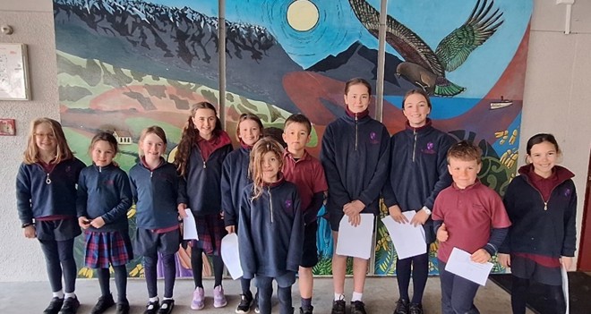 a group of students in school uniforms standing in front of a mural