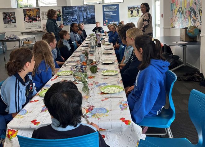 a group of children sitting at a long table
