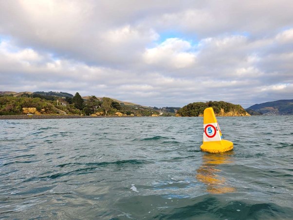a bright yellow buoy floating on a harbour