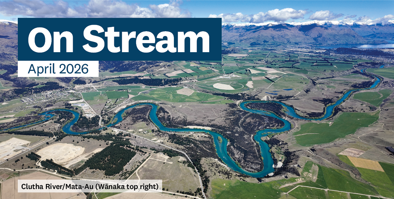 a blue river winding through farmland with a lake in the background