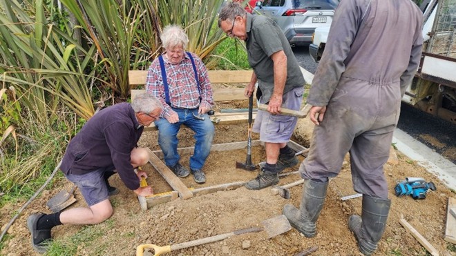 a group of people working on a project with building tools around them
