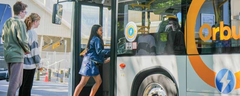 People getting on an electric bus, with Orbus and I'm electric logos clearly visible 