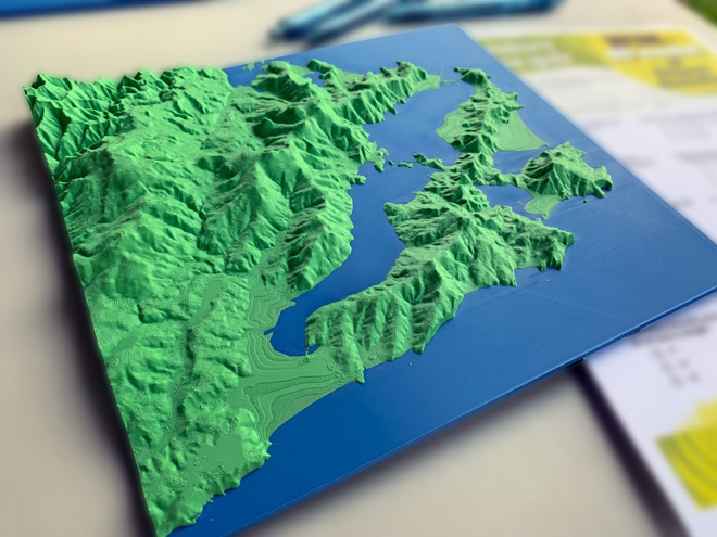 a 3D model of mountains and water sitting on a table