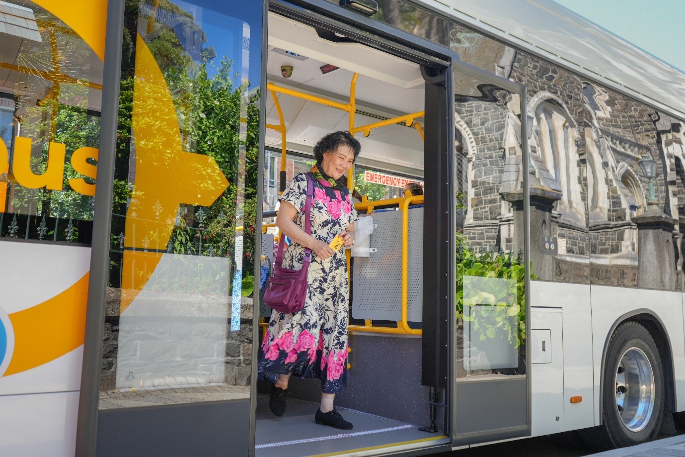 a smiling person getting off a bus